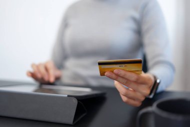 İnternetten alışveriş yapan yetişkin bir kadın kredi kartı bilgilerini internetten alışveriş başvurusuna ekliyor..