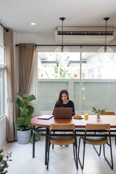 Work from home concept a female freelancer looking happy while working online in her own space during Covid 19 pandemic.