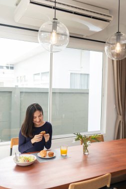 Evinde salata yedikten sonra tatlı olarak portakal suyu yiyen genç bir kadının yemek konsepti..
