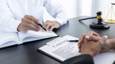 Hukuk, terazi ve çekiç masaya yatırıldı. İki avukat sözleşme kağıtları ve hukuk konularında tartışıyor..