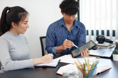 Ofis işi kavramı. Bir işadamı, iş arkadaşına ilginç bilgiler sunan bir bar grafiği gösteriyor..