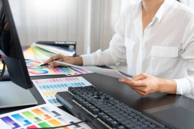 yaratıcı grafik tasarımcısı ofiste çalışırken resim düzenlemek için renk ölçeği seçiyor