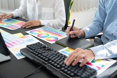Grafik tasarımcısı veya yaratıcı birlikte çalışarak grafik tableti ve çalışma arkadaşı ile çalışma masasında bir stil kullanarak renklendirme