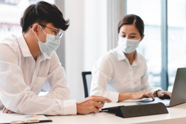 Korumacı maskeler takan serbest çalışanlar, birlikte çalışırken mesafeyi koruyorlar..