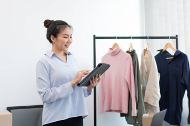 Canlı alışveriş kavramı. Bir kadın tüccar internet üzerinden bilgi ve fotoğraf yüklüyor..