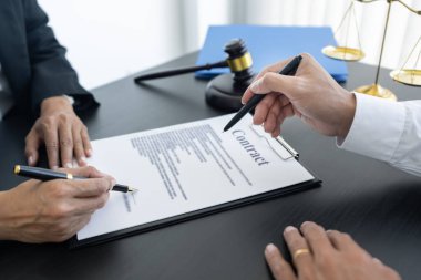 Hukuk, terazi ve çekiç masaya yatırıldı. İki avukat sözleşme kağıtları ve hukuk konularında tartışıyor..