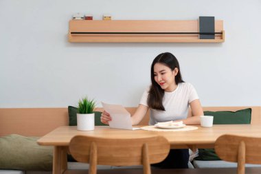 Oturma odası konsepti. Elinde gazete tutan güzel bir bayan. Bir diğeri de oturma odasında bir fincan kafein içeceği tutuyor..
