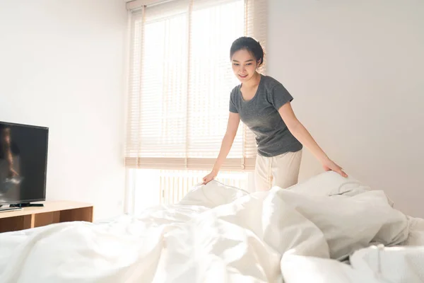 ベッドルームコンセプトA女性大人取得後にベッドを作るための毛布の端をつかむことによってルーチンを行う朝の時間 — ストック写真