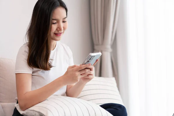 Living room concept a long-haired girl spending time on the electronic devices in the cozy room.