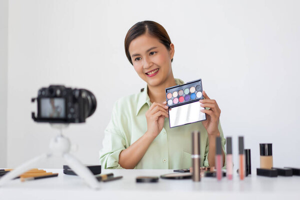 Женщина-блоггер красоты рассматривает качество красочной палитры теней для век в качестве нового продукта прибытия.