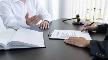 Hukuk, terazi ve çekiç masaya yatırıldı. İki avukat sözleşme kağıtları, hukuk konuları ve kararlılık hakkında tartışıyor..