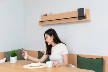 Oturma odası konsepti. Elinde gazete tutan güzel bir bayan. Bir diğeri de oturma odasında bir fincan kafein içeceği tutuyor..