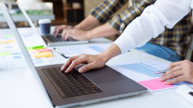 İş adamı finans müfettişi ve sekreteri rapor hazırlıyor ve iş arkadaşıyla birlikte modern bir çalışma alanında beyin fırtınası yapıyorlar..