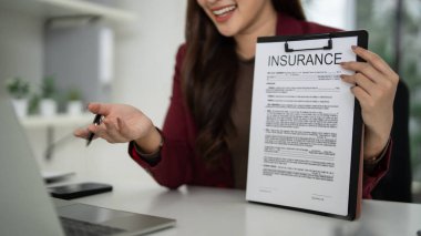 Yetişkin Asyalı kadın satış danışmanı, sigorta poliçesinin detaylarını müşterilere açıklıyor. Profesyonel iş toplantısı. Uzman kılavuz mülkiyet yatırımı.