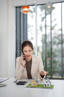 Profesyonel kadın müşterilerin ev finansmanı, iş yeri, gelecekteki ev sahipliği için mali planlama tartışması hakkında akıllı telefon kullanması