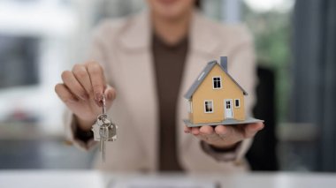 Profesyonel emlakçı, müstakbel yatırım fırsatını temsil eden minyatür ev ve anahtarları gösterdi
