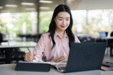 Dijital tablette çalışan Asyalı kadın dizüstü bilgisayar stili kulaklıklar online modern çalışma alanı profesyonel yaratıcı teknoloji çözümleri verimlilik yeniliği üzerine çalışıyor