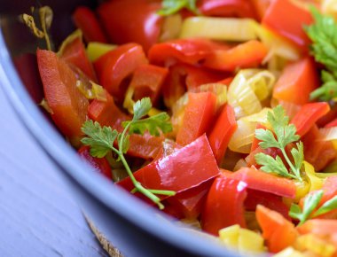 Bir tavada karışık taze sebze (biber, pırasa, otlar)