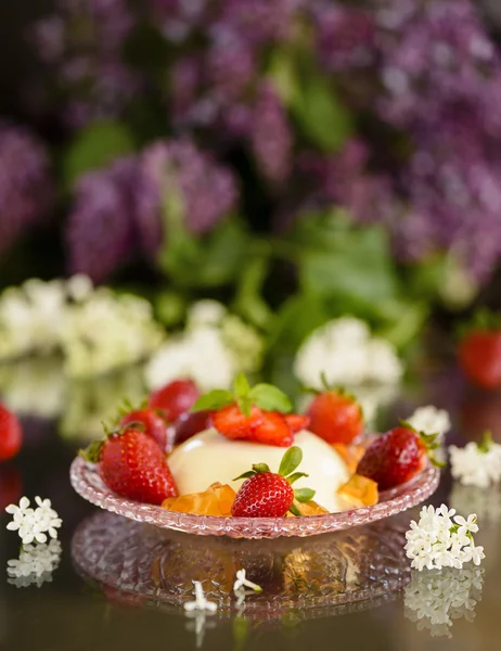 Italian dessert pannacotta with strawberries and lilac flowers — Stock Photo, Image