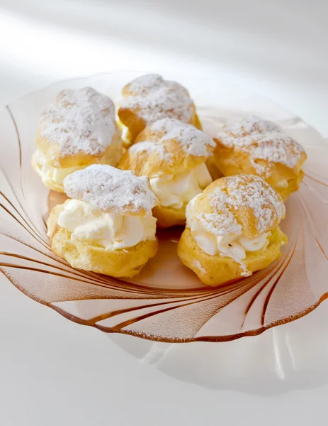 Cream puff lub profiterole z nadzieniem i sproszkowany cukier, polewa, na białym tle, białym tle — Zdjęcie stockowe