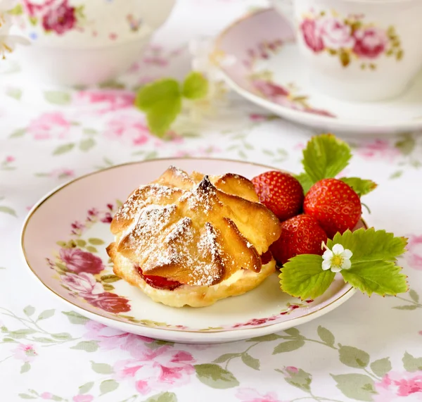 Cream puffs or profiterole filled with whipped cream, powdered sugar topping served with strawberries on the table — Stock Photo, Image