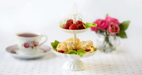 크림 퍼프 또는 profiterole 고원 아침 식사 테이블에 딸기와 함께 하는 휘 핑된 크림으로 가득 — 스톡 사진