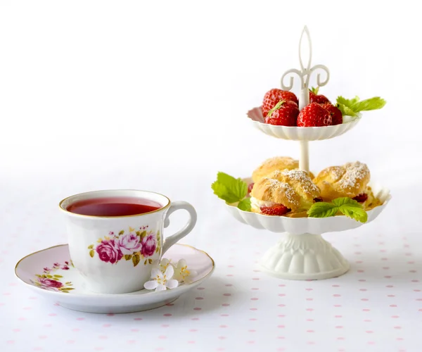 奶油泡芙装满奶油配草莓在早餐桌上高原 — 图库照片