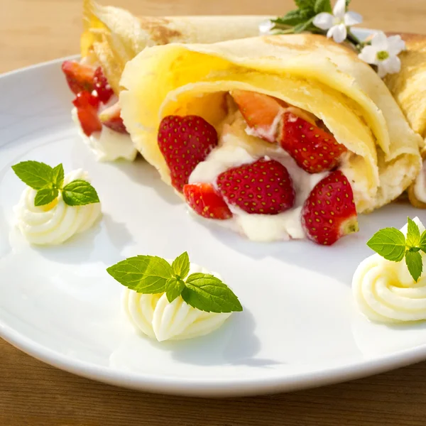 A dessert plate with pancakes, strawberry, whipped cream and mint — Stock Photo, Image