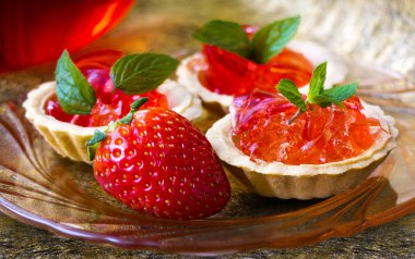 Çilek, jöle ve altın zemin üzerine nane ile küçük cupcakes