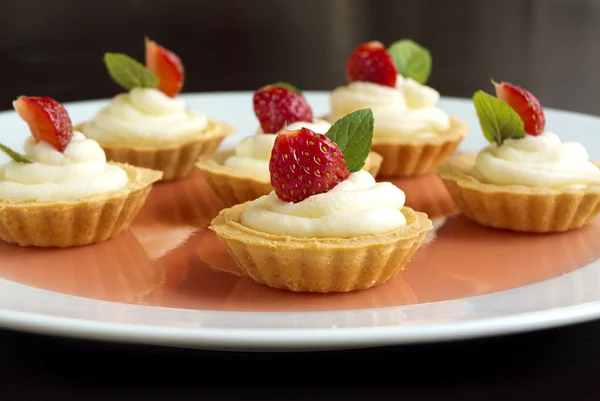 Tiny cupcakes with strawberry, whipped cream, jelly and mint — Stock Photo, Image