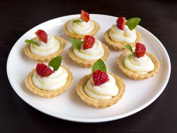 Viele Kuchen mit Schlagsahne, frischen Früchten und Minzen — Stockfoto