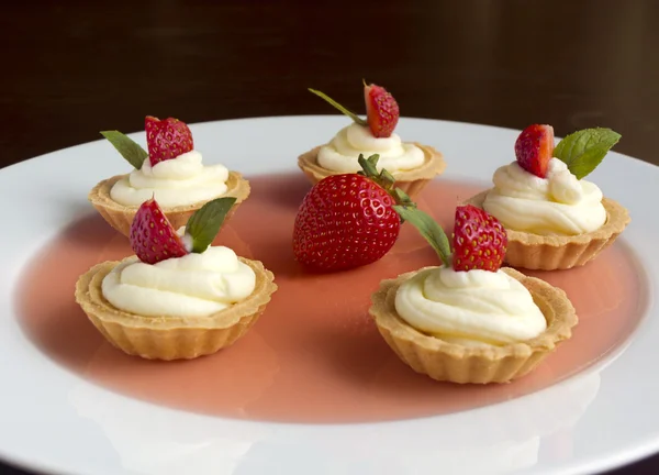 Muffins med jordgubbar, vispad grädde, gelé och mynta — Stockfoto
