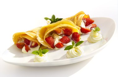 Krep, çilek meyve, krem şanti ve nane ile bir tatlı tabağı