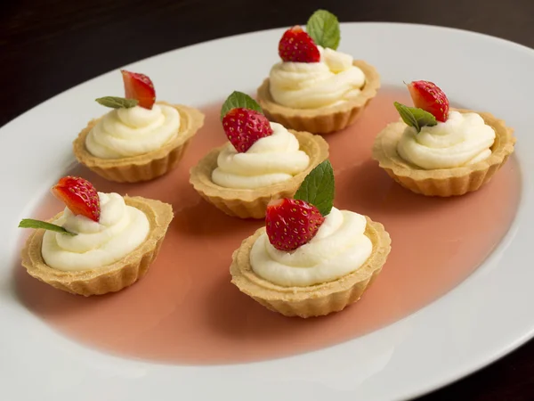 Petits gâteaux à la fraise, crème fouettée, gelée et menthe — Photo