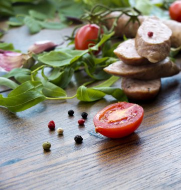 Tütsülenmiş sosis otlar, yeşillik ve domates ile