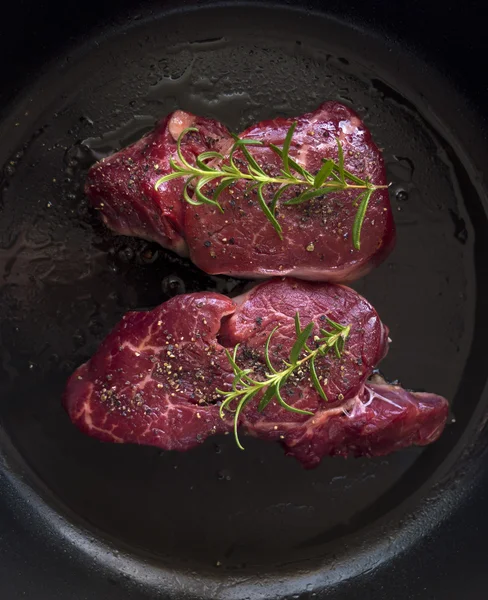 Bife de carne em uma panela escura — Fotografia de Stock