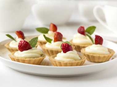 Birçok kek, taze meyve (çilek), ile cupcakes çırpılmış krema, jöle ve nane şekeri