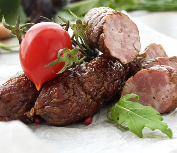 Smoked sausage with greens and tomatoes on round plate — Zdjęcie stockowe