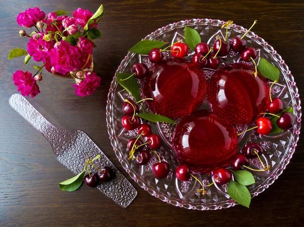 Dolce rinfrescante estivo - gelatina di bacche rosse con ciliegie su sfondo scuro, focus selettivo — Foto Stock