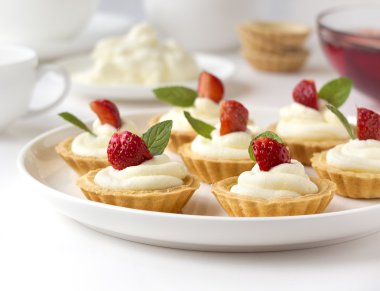 Birçok kek, taze meyve (çilek), ile cupcakes çırpılmış krema, jöle ve nane şekeri