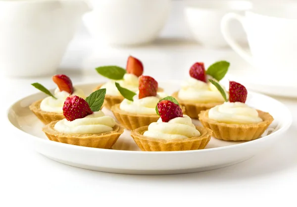 De nombreux gâteaux, cupcakes aux fruits frais (fraises), crème fouettée, gelée et menthe — Photo