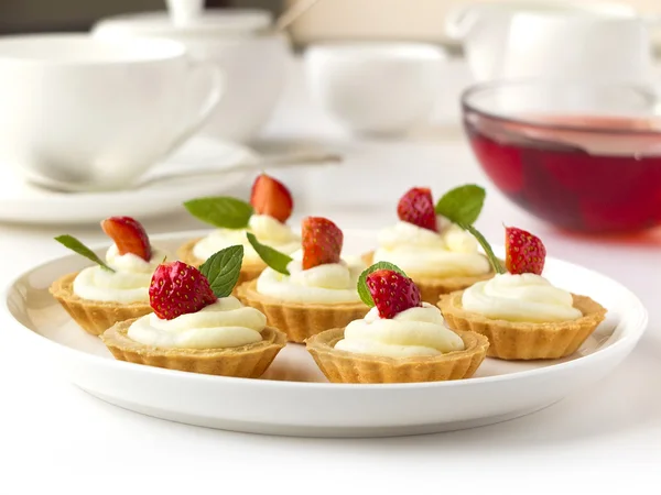 De nombreux gâteaux, cupcakes aux fruits frais (fraises), crème fouettée, gelée et menthe — Photo