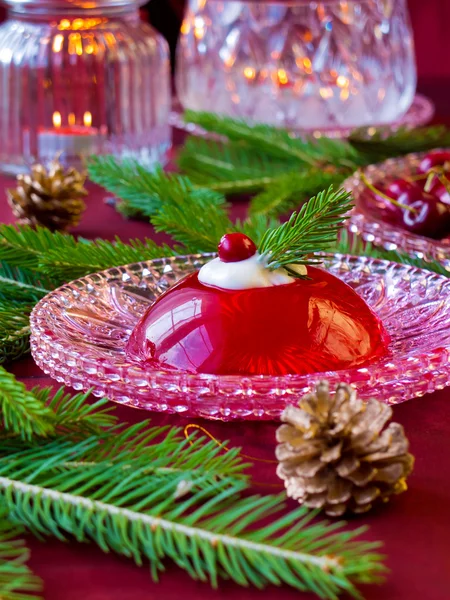 Red berries jelly on glass plate with christmas tree — Stock Photo, Image