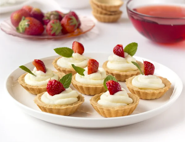 De nombreux gâteaux ou mini tartes aux fruits frais, crème fouettée et menthe — Photo