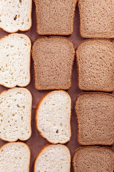 Vy ovanifrån på färskt vitt och svart bröd, skivad i jämna bitar Stockbild