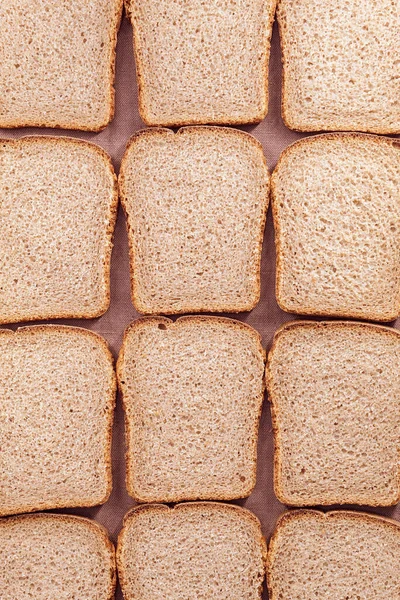 Frisches Schwarzbrot, in rechteckige Stücke geschnitten, liegt in einer bestimmten Reihenfolge auf einem Küchentuch — Stockfoto