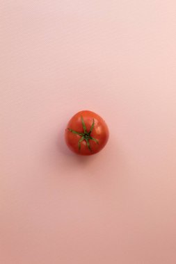 Dikey fotoğraf sağlıklı ve lezzetli çiğ yiyecekler gösteriyor. Pembe bir domates. Bütünler ve temizler. Orta Domates.