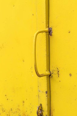 Fotoğraf, tasarım çözümleri için bir grafik kaynağı görüntüsünü gösteriyor. Arkaplan ya da desen şeklinde, sarıya boyanmış. Saplı bir garaj kapısı.