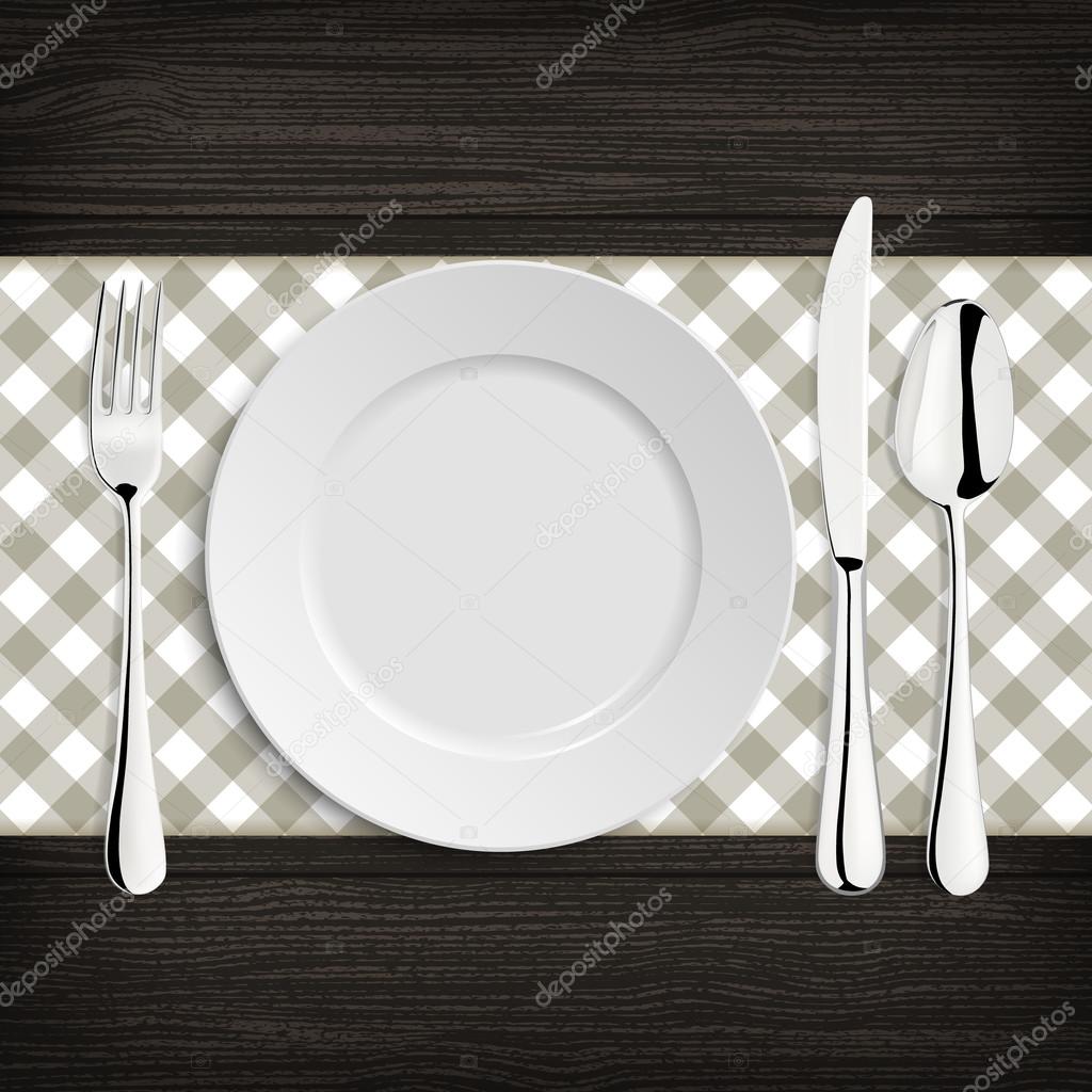 Plate with spoon, khife and fork on a wood table