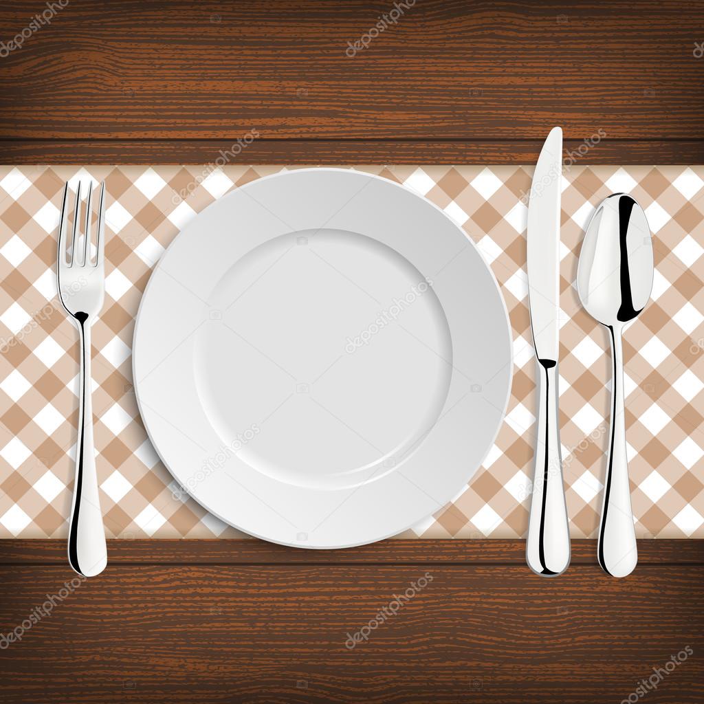 Plate with spoon, khife and fork on a wood table